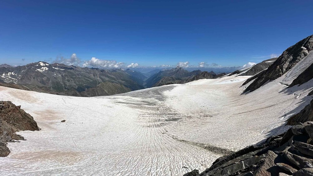 A glacier with a valley and mountains in the background. 4