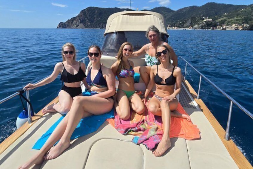 A group of people on a boat with a mountainous coastline in the background. 1