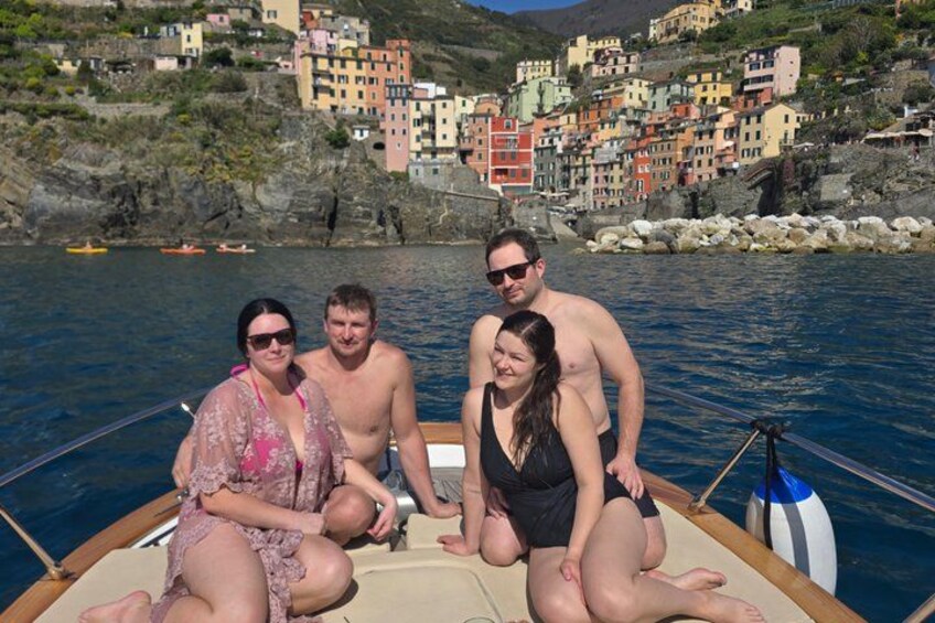 Un grupo de personas en un barco, con un pueblo costero al fondo. 5