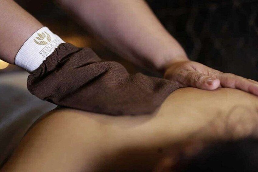A person receiving a massage with a brown towel wrapped around their leg. 1