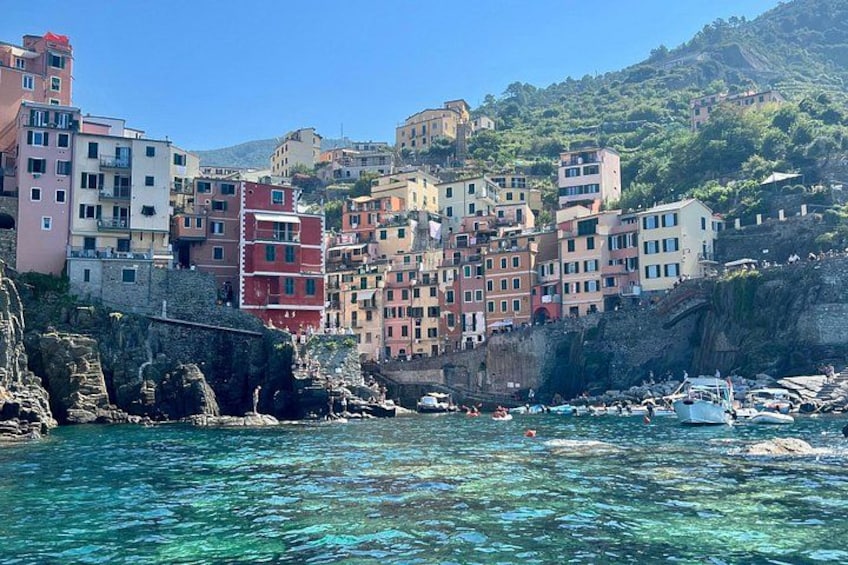 A coastal town with colorful buildings, clear blue water, and boats. 5