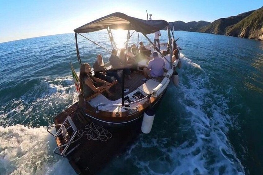 A boat with people on board, a clear sky, and a body of water. 2