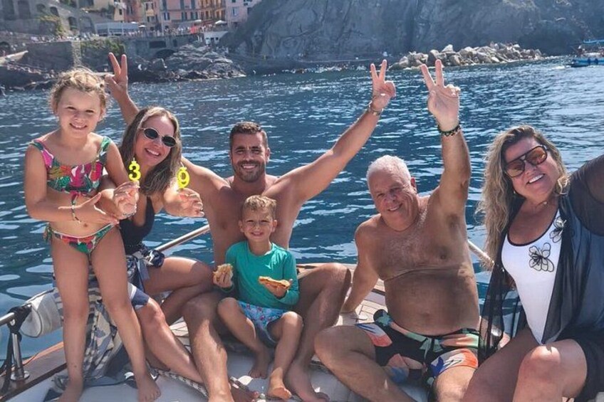 A group of people on a boat with rocky coastline in the background. 4