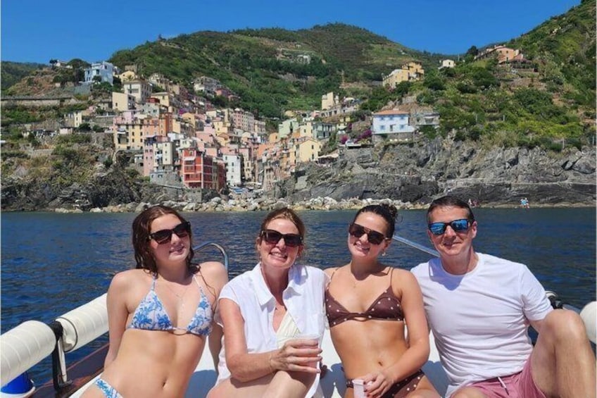 Un grupo de personas en un bote con un pueblo costero al fondo. 4