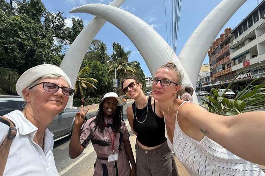 A group of people taking a selfie with a large white sculpture in the background. 4