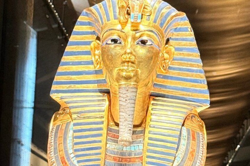 A golden pharaoh's head with a striped headdress and a cobra figure. 1