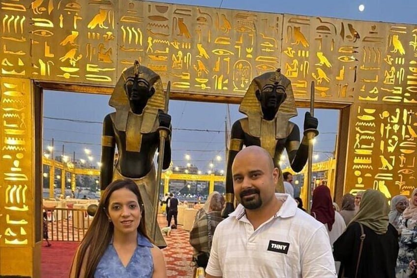 Two large statues of ancient Egyptian figures in front of a wall with hieroglyphs. 1
