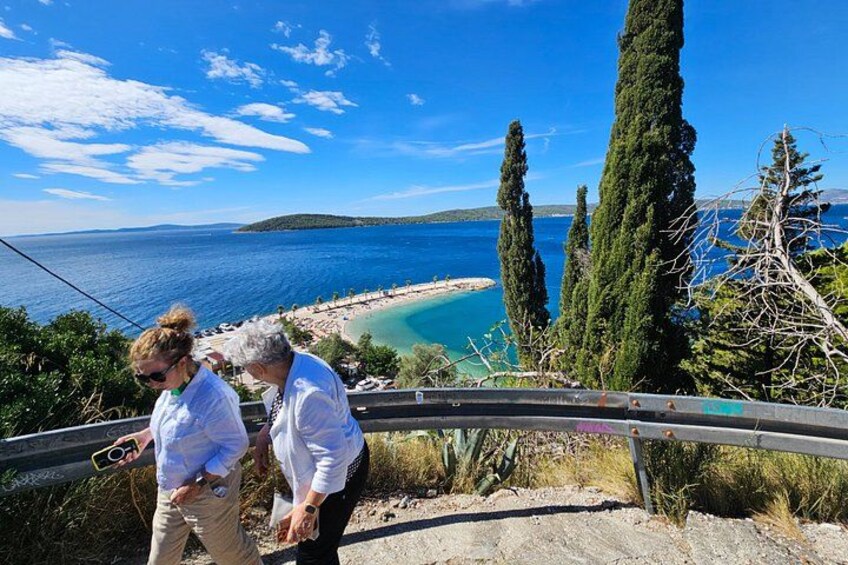 Un paisaje costero con playa, cipreses y cielo despejado. 5