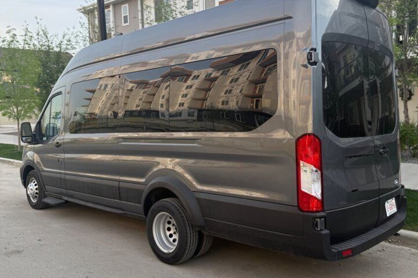 Una camioneta gris estacionada en una calle con edificios al fondo. 3