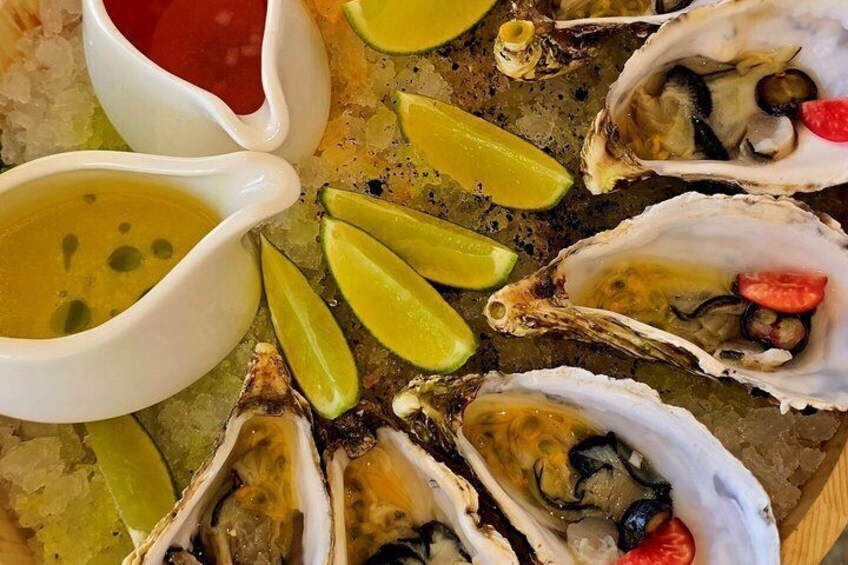Un vassoio di ostriche con spicchi di limone e due salse. 3