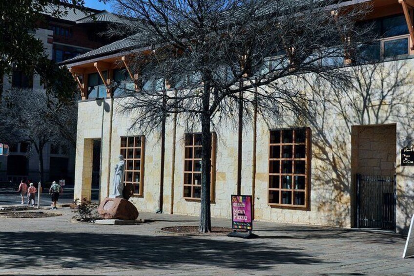 A building with large windows, a statue, and a signboard. 2