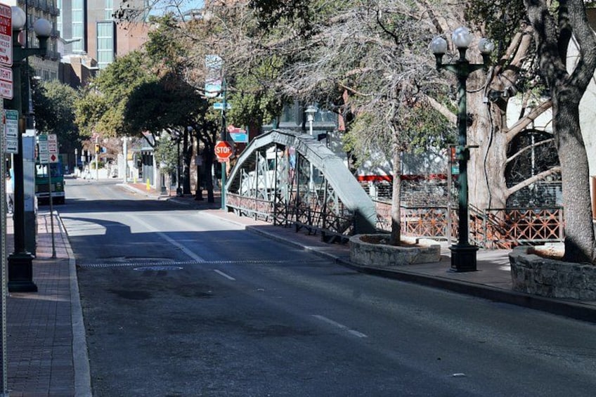 Eine Straße mit einer Fußgängerbrücke, Bäumen und einem Stoppschild. 5