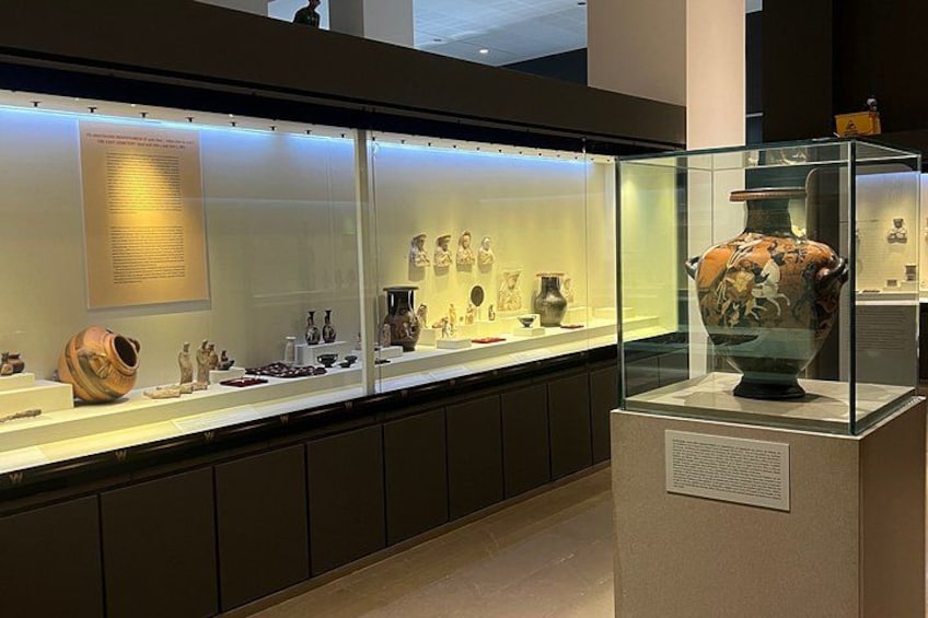 Una exhibición de museo con vitrinas de vidrio que contienen cerámica y artefactos. 2