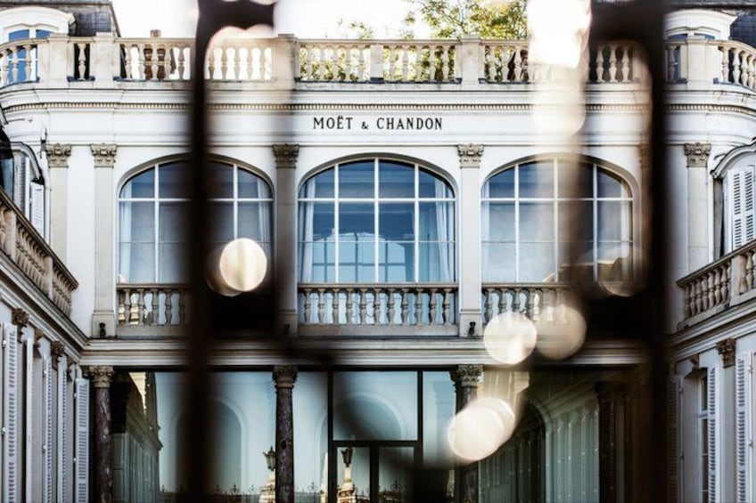Un bâtiment doté de fenêtres en arc de cercle et portant l’inscription « MOËT & CHANDON » sur sa façade. 2