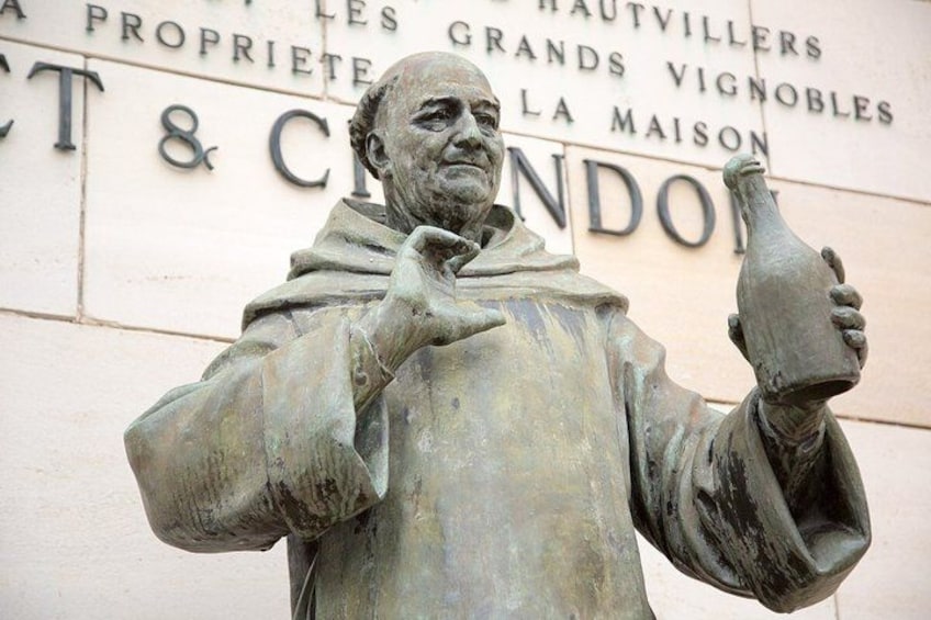 Une statue représentant un homme tenant une bouteille, avec un texte en arrière-plan. 5