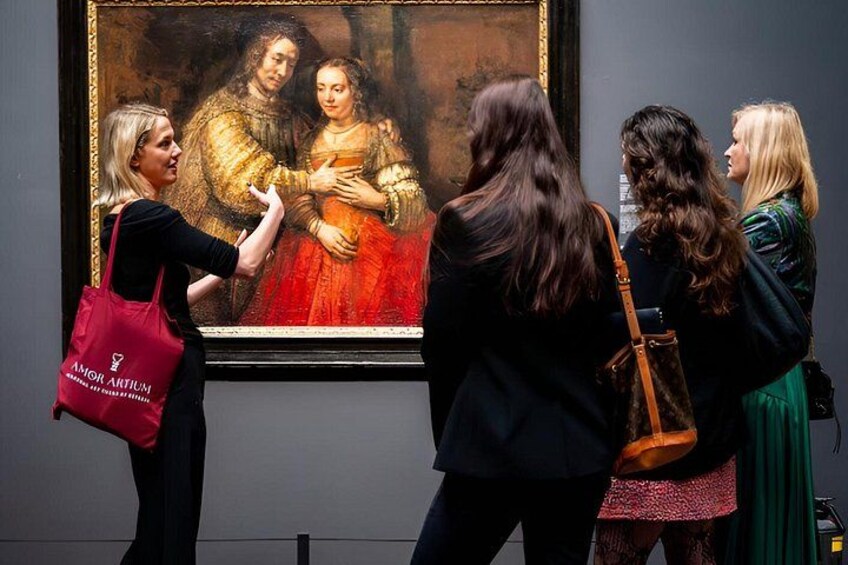 Een groep mensen bekijkt een schilderij in een museum. 5