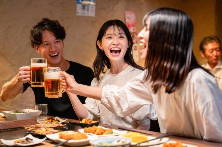 A group of people toasting with beer mugs at a table with various dishes. 4