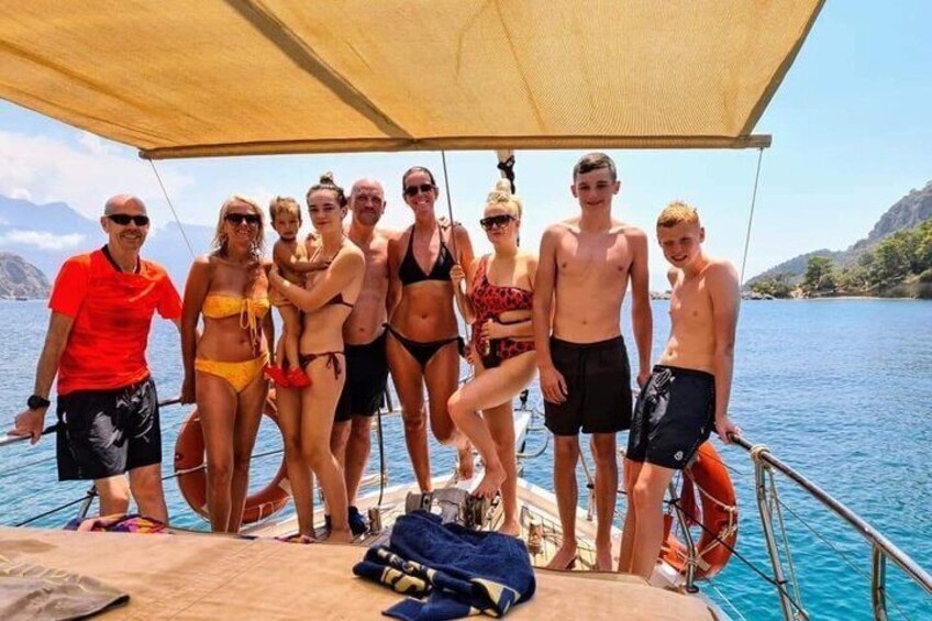 Un gruppo di persone su una barca con un paesaggio montuoso sullo sfondo. 5