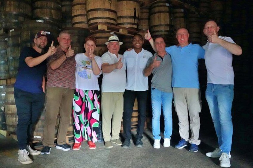 A group of people standing in front of wooden barrels. 2
