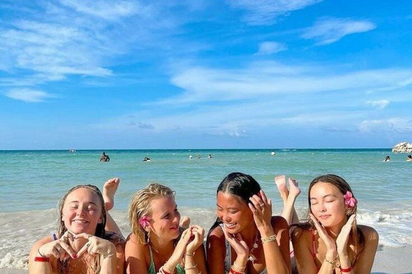 Eine Gruppe von Menschen am Strand, im Hintergrund Meer und ein klarer Himmel. 3