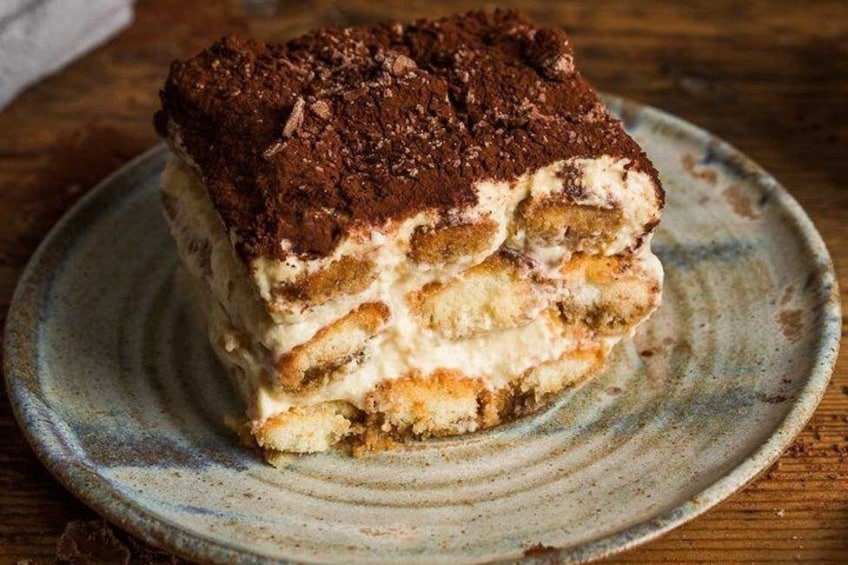 A slice of tiramisu on a ceramic plate. 2