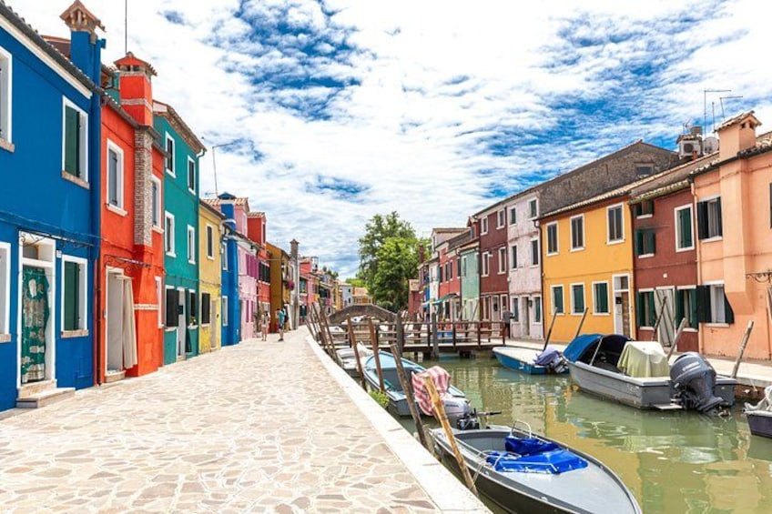 A canal with colorful buildings on one side and boats docked on the other. 1