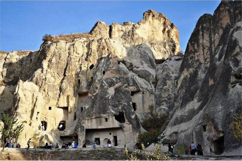 A rock formation with carved niches and a cave entrance. 5