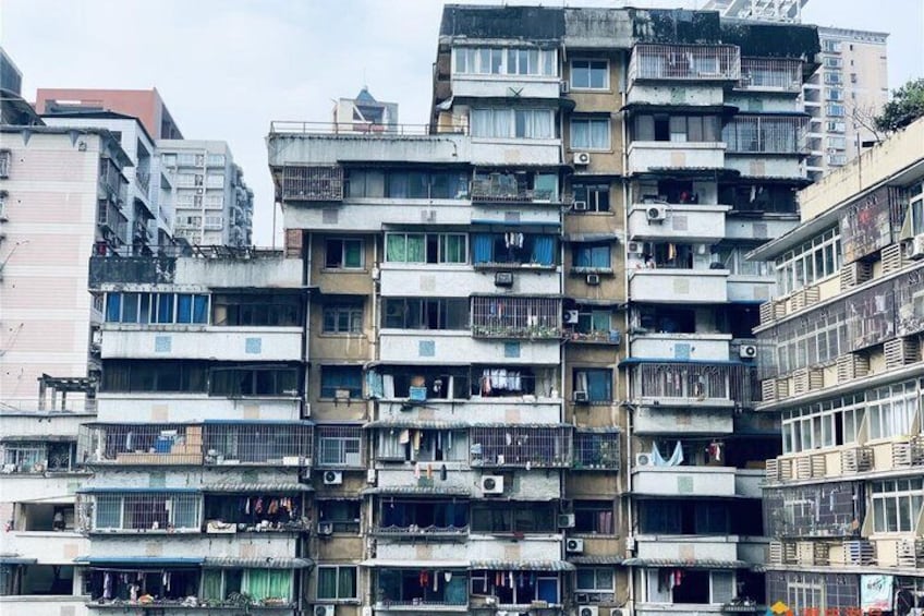 Een meerlaags woongebouw met balkons, airconditioners en zichtbare was. 2