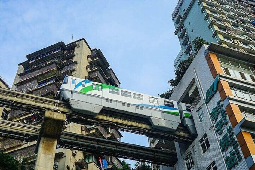Een trein op een verhoogde rails boven een stadsgezicht. 5