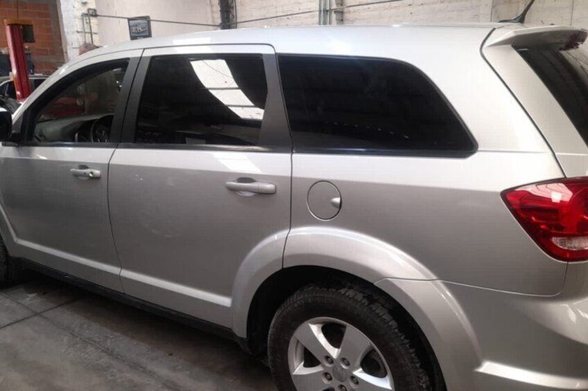 Un SUV argento parcheggiato in un garage, con una ruota posteriore e uno sportello laterale ben visibili. 4