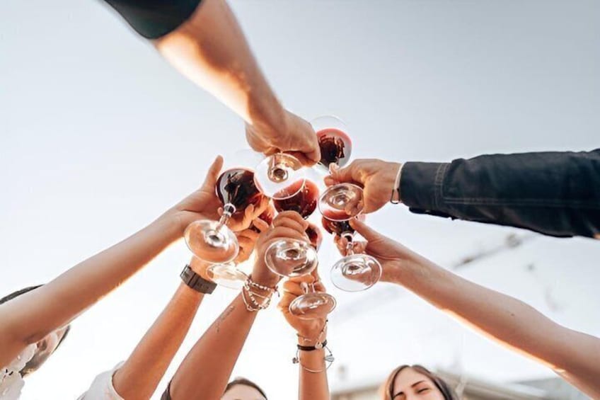 A group of people holding wine glasses in a circle. 3