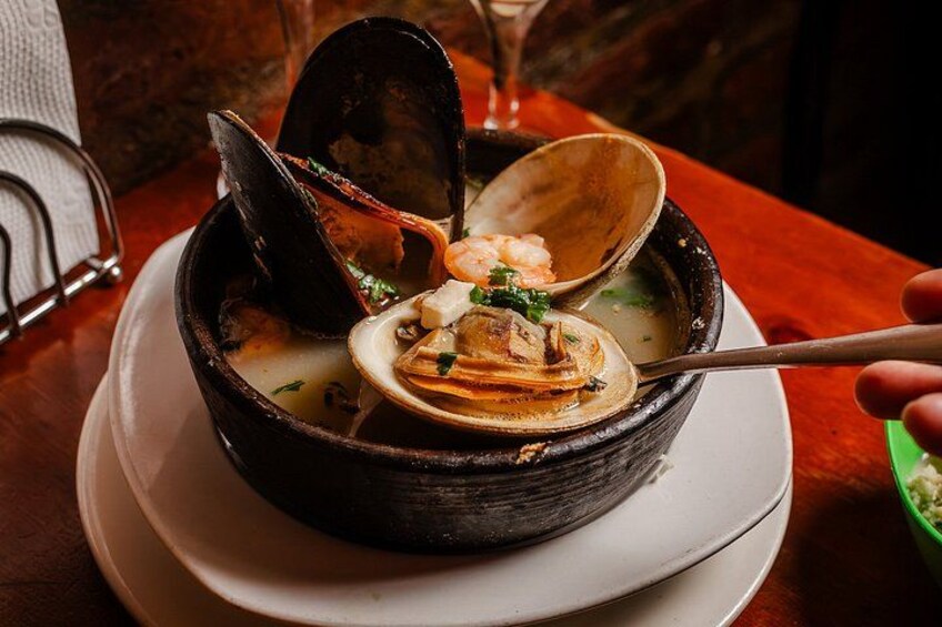 A seafood dish with mussels and shrimp in a bowl. 3