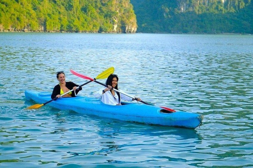 Two people kayaking on a calm lake with green hills in the background. 4