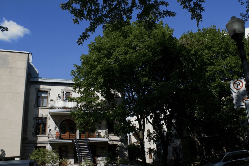 A two-story building with a balcony, a no parking sign, and a street lamp. 3