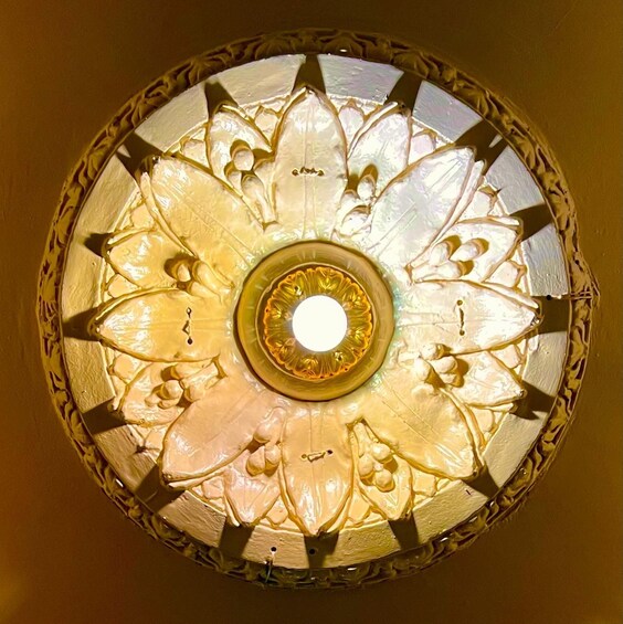 A stained glass ceiling with floral patterns and a central circular design. 2