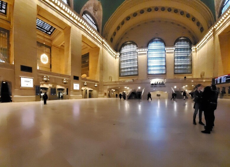 A spacious indoor area with high ceilings, large windows, and a central staircase. 1
