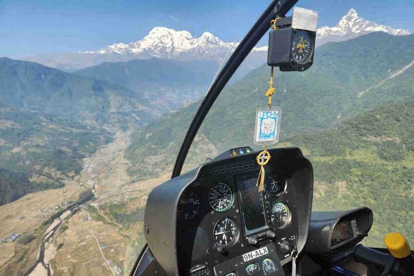 En helikoptercockpit med ett bergigt landskap i bakgrunden. 3