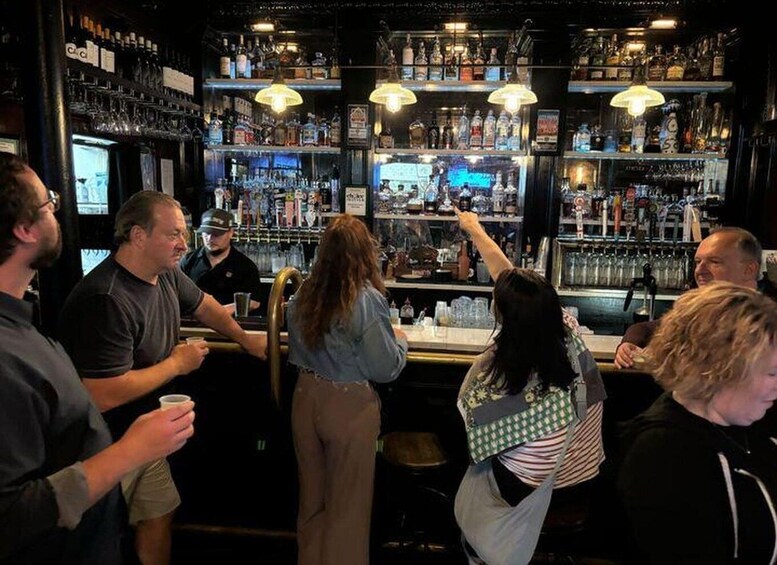 A bar with shelves of bottles and a person pointing at something. 2