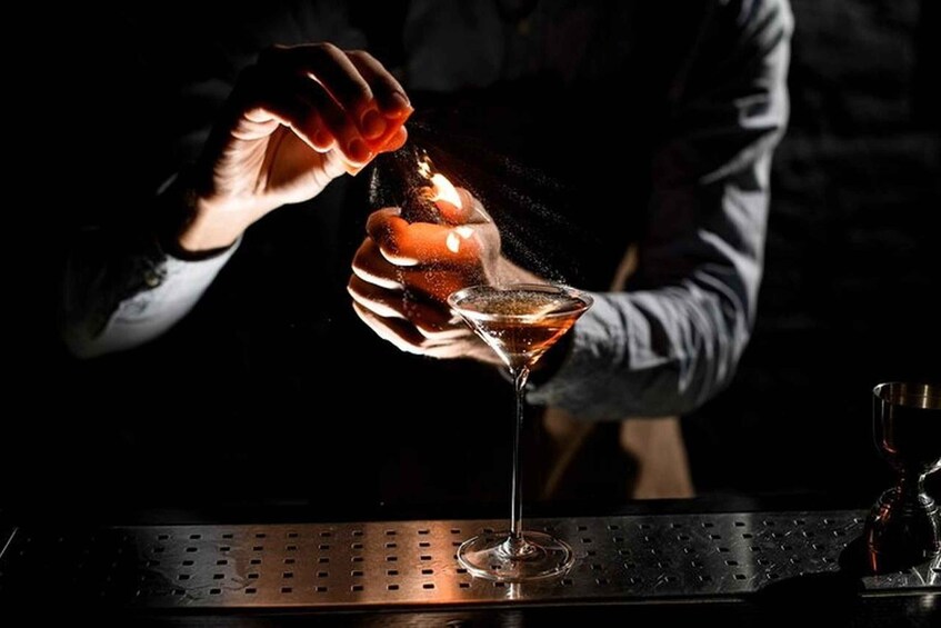 A person pouring a liquid into a martini glass. 3