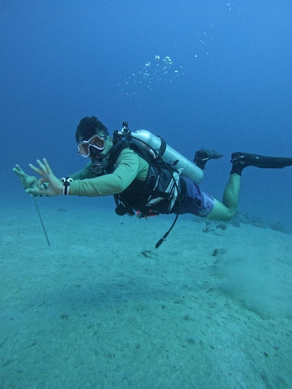 A diver underwater with a snorkel and fins, reaching out towards the surface. 2
