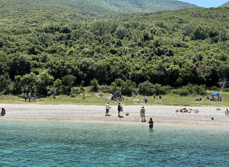 A beach with people sunbathing and walking along the shore. 3