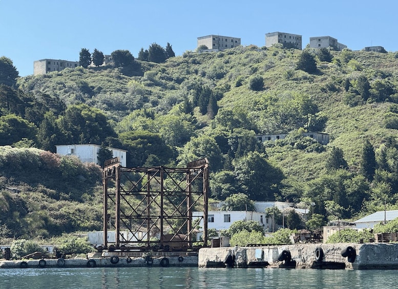 A coastal scene with a ship's crane, a lighthouse, and a hill with buildings. 2