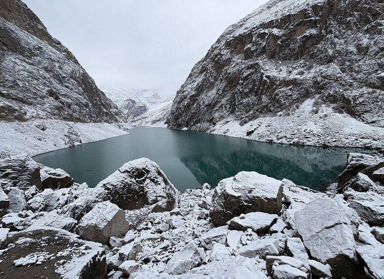 A snow-covered lake surrounded by rocky cliffs. 2