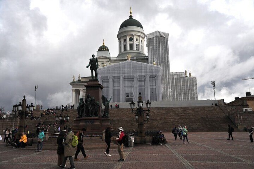 A large public square with a prominent statue, a domed building, and a modern skyscraper in the background. 1