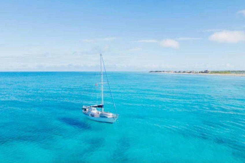 A sailboat on turquoise waters with a clear sky. 3