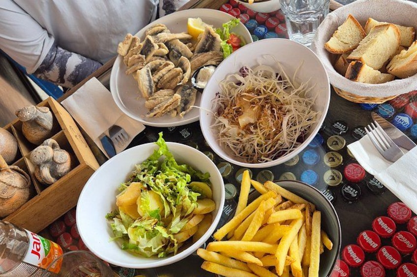 A table with various dishes including fries, salad, and bread. 3