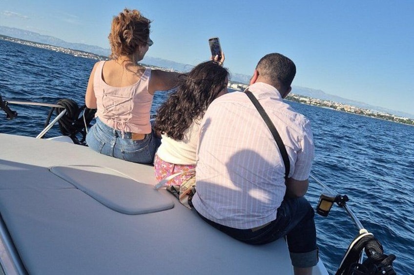 A group of people on a boat, looking at a smartphone. 5