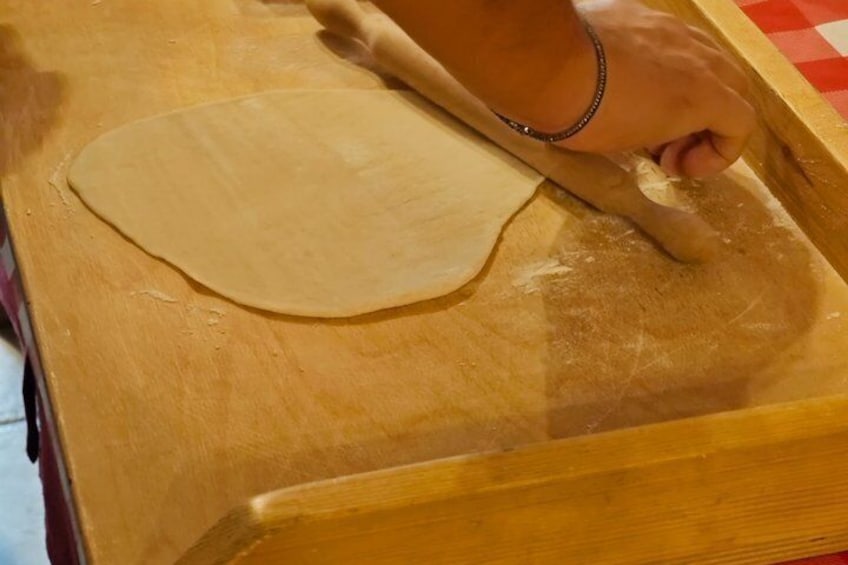 Una mano amasando masa sobre una superficie de madera. 4