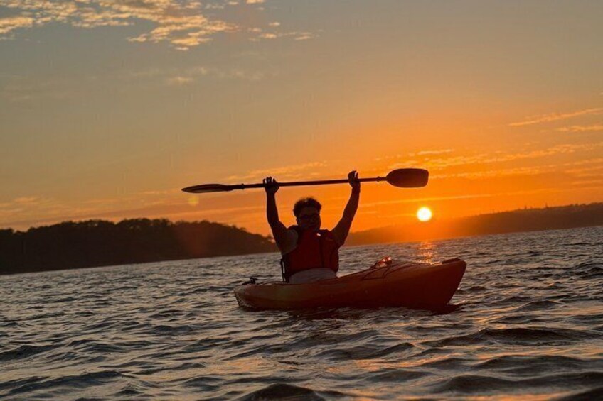 Una persona fa kayak su un'acqua calma al tramonto. 2