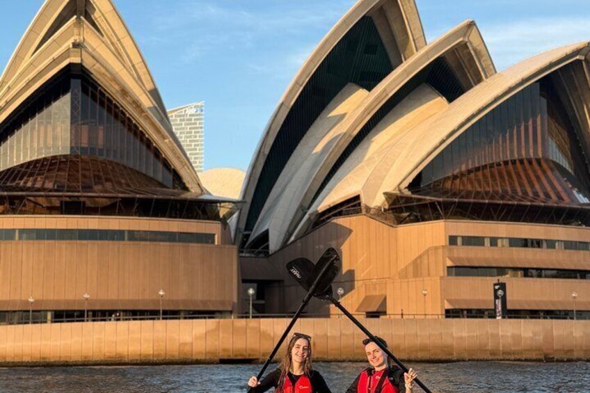 La Sydney Opera House con due persone che pagaiiano in primo piano. 1